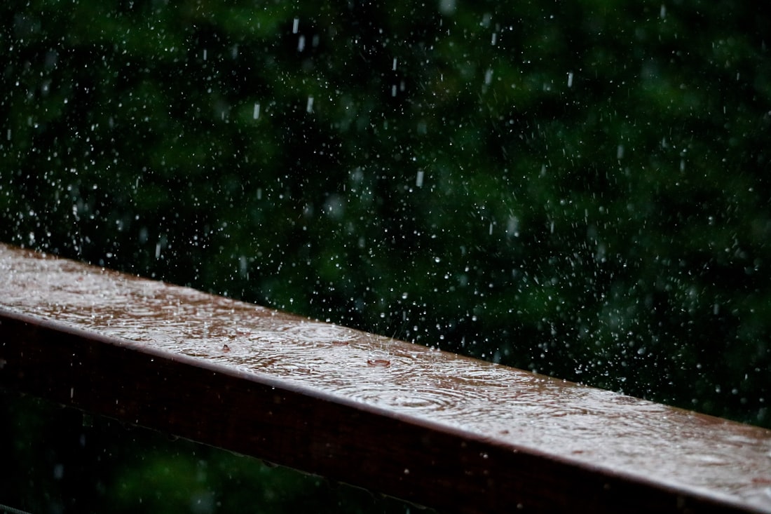 大雨打在陽台木欄杆上，雨珠四濺